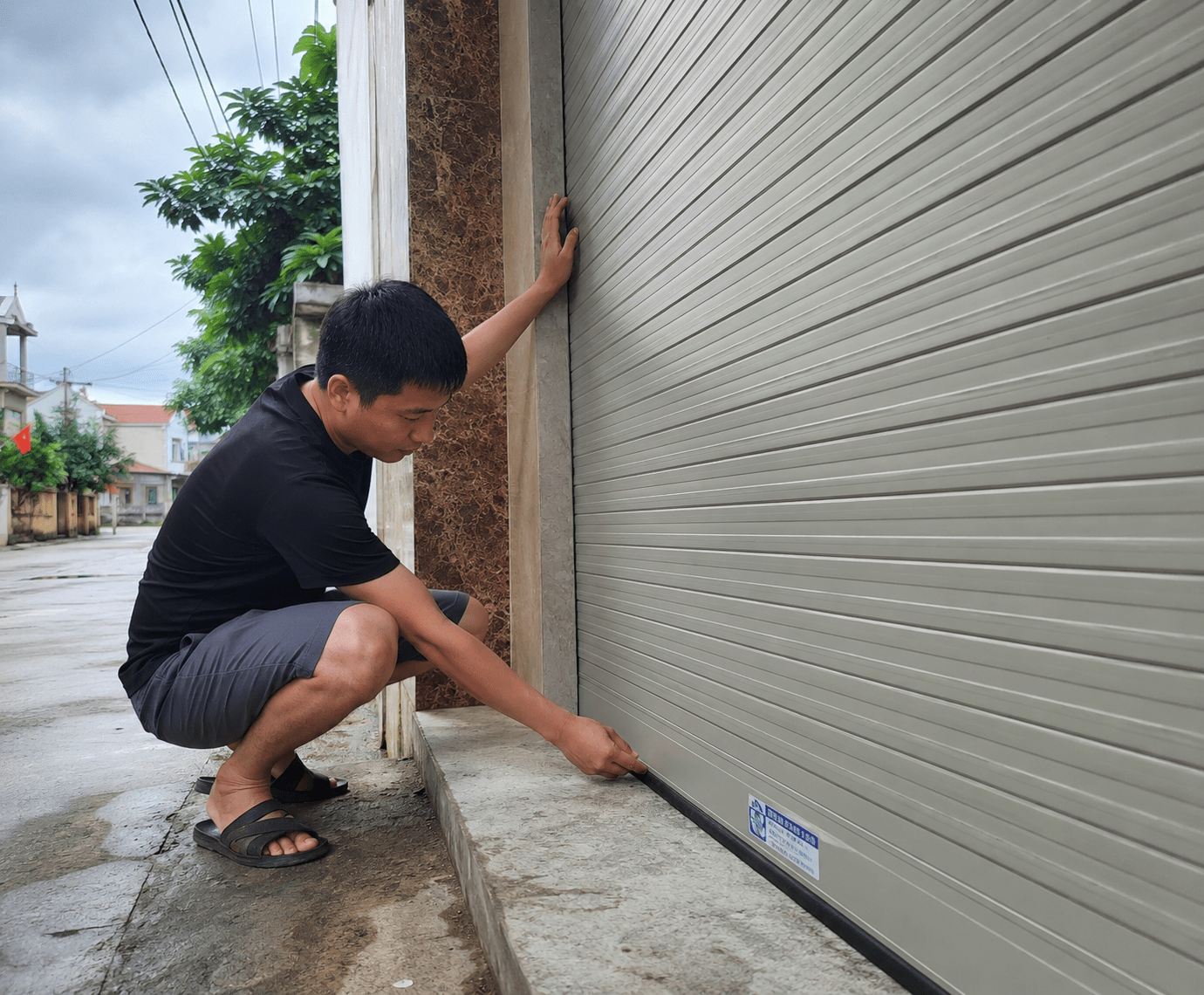Đóng cửa cuốn xuống sát nền, kiểm tra khe hở hai bên ray và phần đáy cửa để kịp xử lý nếu cửa bị vênh, kẹt hoặc không đóng kín trước khi bão đến